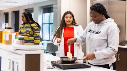 Dietitian Blanca Cats works with a student in the teaching kitchen.