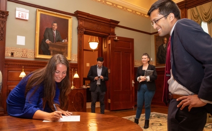 Jacquelyn A. Suárez sigining a document